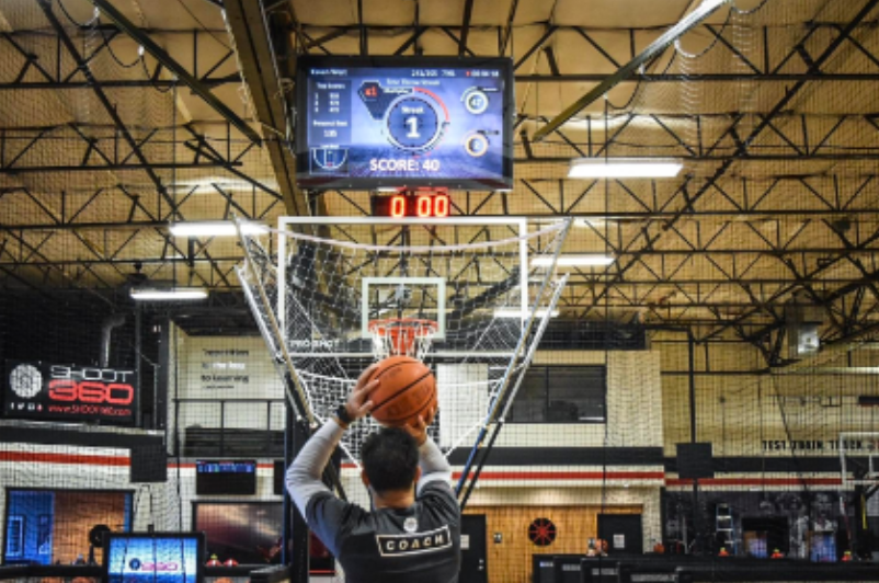 Player taking tracked shooting reps under a live scoreboard